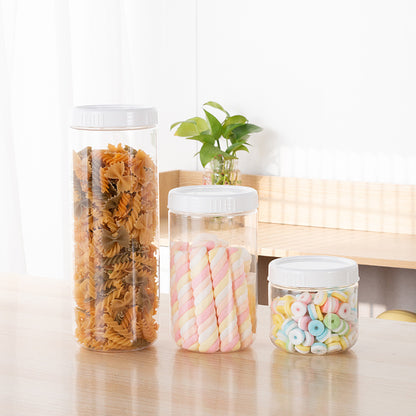 Modern minimalist round grain storage bottles with pasta, candy, and colorful treats, perfect for kitchen organization.