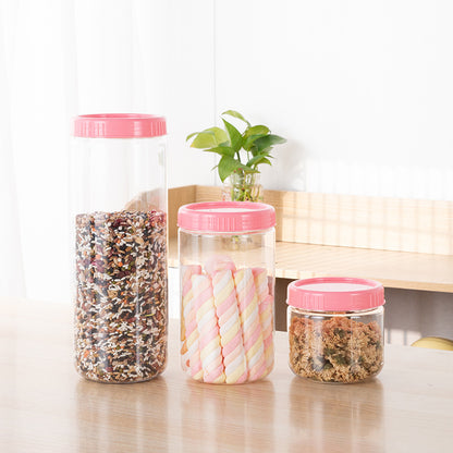 Modern minimalist grain storage boxes in pink, showcasing various shapes and sizes on a kitchen table with greenery.