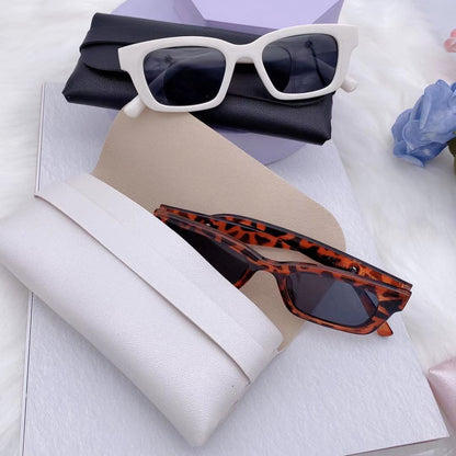 Stylish sunglasses resting on PU storage boxes in white and black, showcasing fashion and organization.